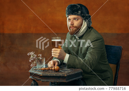 Portrait of red headed and bearded man playing famous artist isolated over dark bacground. Eras comparison Portrait of red headed and bearded man playing famous artist isolated over dark bacground. Eras comparison 77988716