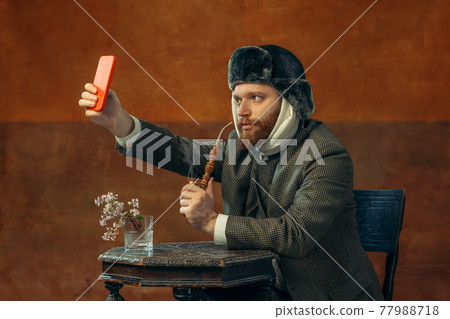 Portrait of red headed and bearded man playing famous artist isolated over dark bacground. Eras comparison Portrait of red headed and bearded man playing famous artist isolated over dark bacground. Eras comparison 77988718
