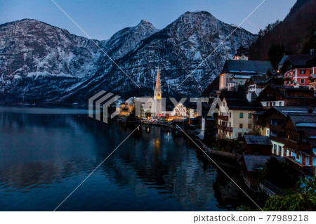 VIew of beautiful Hallstatt lake and famous church during late evening after sunset in early spring with mountain ranges VIew of beautiful Hallstatt lake and famous church during late evening after sunset in early spring with mountain ranges 77989218