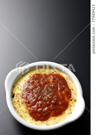 Doria and gratin with plenty of melted and browned cheese taken on a black background (overhead view) Doria and gratin with plenty of melted and browned cheese taken on a black background (overhead view) 77989423