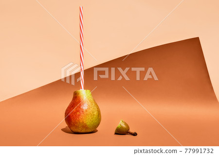 Funny fruits on colorful pastel background. Pear with drinking straw as fruit juice concept. 77991732