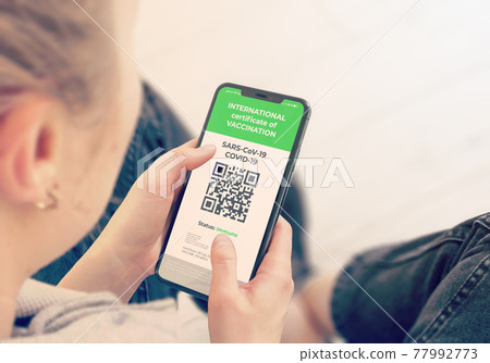 COVID-19: Digital green certificates on Cellphone Screen. COVID-19: Digital green certificates on Cellphone Screen. 77992773