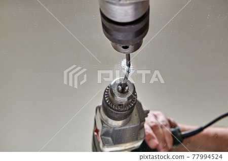 Drilling hole in glass or mirror with special drill bit. Drilling hole in glass or mirror with special drill bit. 77994524