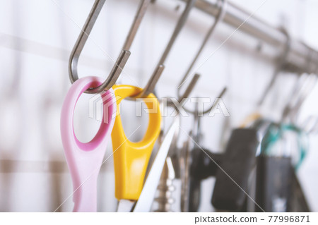 Hook kitchen close-up. Can opener, scissors and corkscrew.  77996871