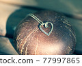 Heart pendant necklace on wood symbol of love Romance Valentine's Day Closeup. Selective Focus 77997865