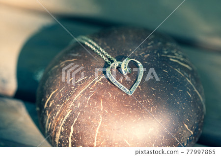 Heart pendant necklace on wood symbol of love Romance Valentine's Day Closeup. Selective Focus Heart pendant necklace on wood symbol of love Romance Valentine's Day Closeup. Selective Focus 77997865