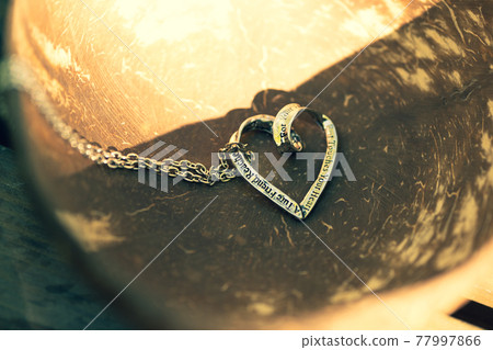 Heart pendant necklace on wood symbol of love Romance Valentine's Day Closeup. Selective Focus Heart pendant necklace on wood symbol of love Romance Valentine's Day Closeup. Selective Focus 77997866