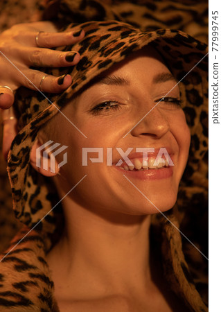 Woman wearing leopard panama laughing out loud while posing 77999745