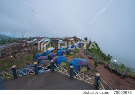 Aerial view of camping tents area with sea fog misty clouds with trees from Phu Tub Berk, Khao Kho, Phetchabun. Nature landscape background in morning. Aerial view of camping tents area with sea fog misty clouds with trees from Phu Tub Berk, Khao Kho, Phetchabun. Nature landscape background in morning. 78000976