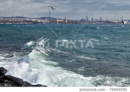 Stormy sea in winter Istanbul, waves foaming off coast in Golden Horn bay. 78004098