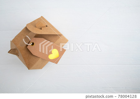 Craft gift box with heart label on white background with space for text. Holiday gift concept. Craft gift box with heart label on white background with space for text. Holiday gift concept. 78004128