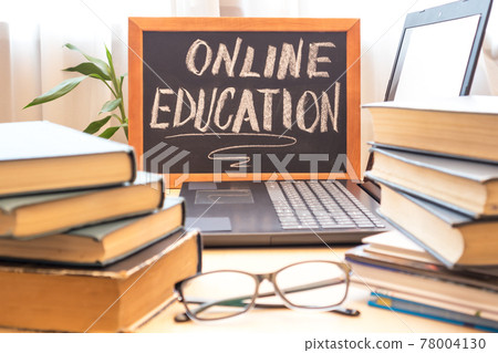Chalk board - online learning, computer and a stack of books. Remote education concept. Chalk board - online learning, computer and a stack of books. Remote education concept. 78004130