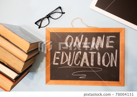 Chalk board - online learning, tablet and a stack of books. Remote education concept. Chalk board - online learning, tablet and a stack of books. Remote education concept. 78004131