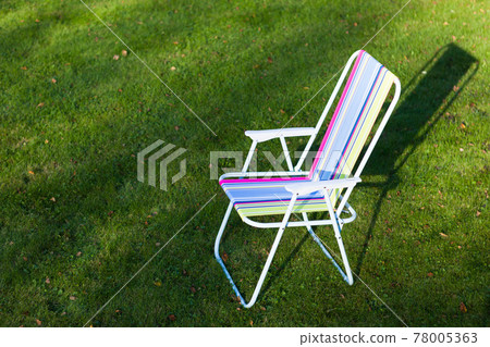garden chair on green lawn background 78005363