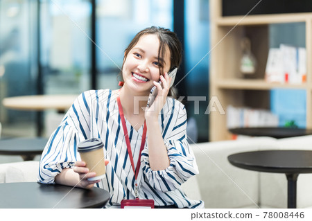 Image of a woman holding a smartphone in the office Image of a woman holding a smartphone in the office 78008446