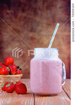 Healthy pink smoothie with strawberry in glass jars 78009164