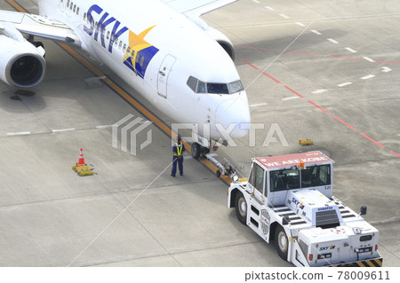 An airplane pulled by a towing car 78009611