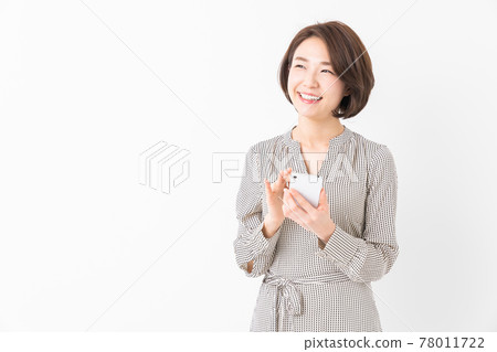 A woman watching a smartphone A woman watching a smartphone 78011722