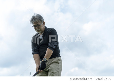 Senior man enjoying ground golf Senior man enjoying ground golf 78012509