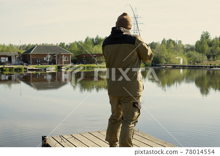 Fisherman catches fish on the lake Fisherman catches fish on the lake 78014554