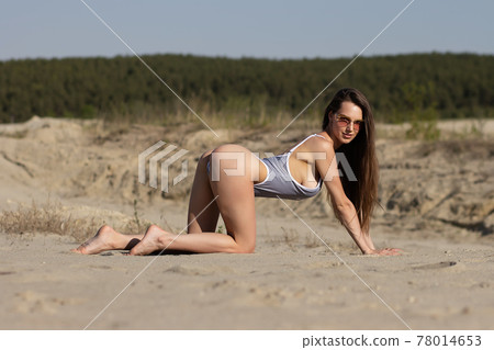 Sensual young lady in bikini enjoying sunny day on sandy beach Sensual young lady in bikini enjoying sunny day on sandy beach 78014653