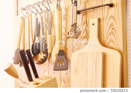 Various kitchen tools hung on the wall 78020815