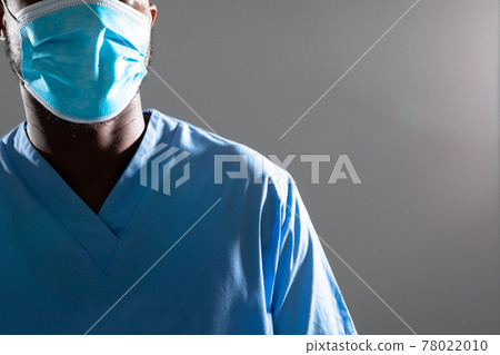 Mid section of african american male health worker wearing face mask against grey background 78022010
