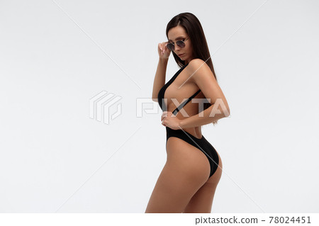 Sexy slim model in stylish black swimsuit 78024451
