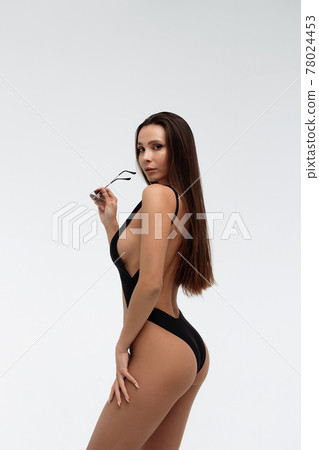 Sexy slim model in stylish black swimsuit 78024453