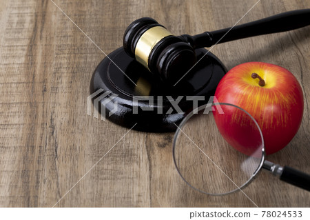 Crime and law - magnifying glass and red apple and gavel 78024533