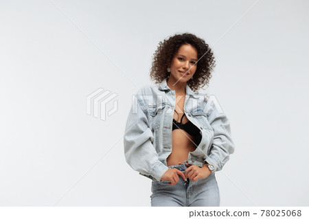 Stylish curly haired woman in denim outfit Stylish curly haired woman in denim outfit 78025068