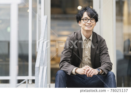 Portrait of a man in his thirties wearing smiling glasses looking at the camera Portrait of a man in his thirties wearing smiling glasses looking at the camera 78025137