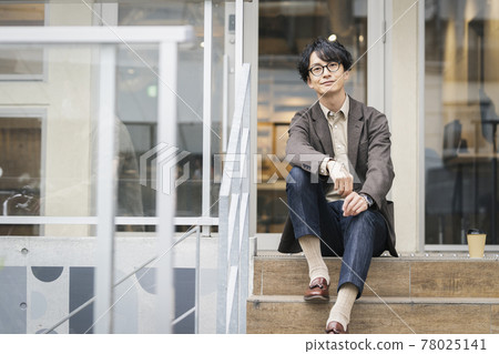 一個三十多歲的男人戴著微笑的眼鏡看著相機的畫像 一個三十多歲的男人戴著微笑的眼鏡看著相機的畫像 78025141