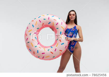 Seductive woman in swimwear with inflatable ring 78025456