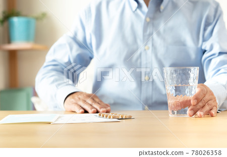 Middle-aged and older men taking medicine 78026358