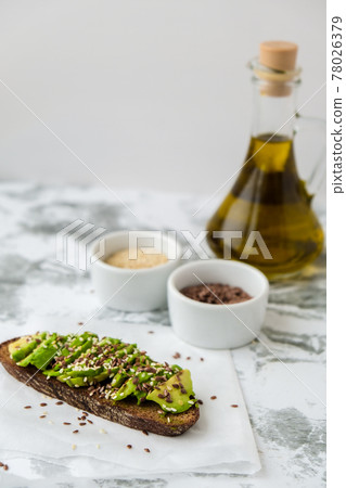Healthy avocado toast on concrete background. Wholegrain bread, sesame flax seeds olive oil. Vegan keto diet. Healthy eating. Trendy guacamole sandwich 78026379