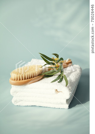 Massage wooden brush on white spa towels with eucalyptus leaves 78026446
