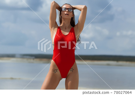 Beautiful woman in swimsuit on beach Beautiful woman in swimsuit on beach 78027064