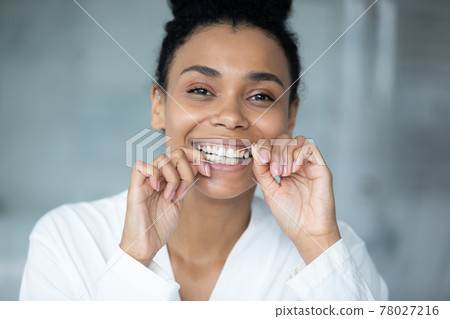 Happy excited millennial Black girl using thin mint thread 78027216