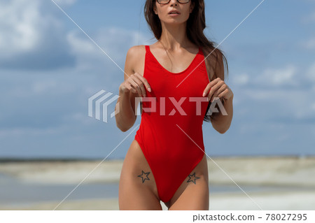 Beautiful woman in swimsuit on beach 78027295