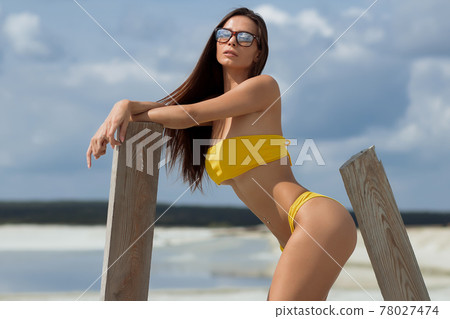Beautiful woman in swimsuit on beach Beautiful woman in swimsuit on beach 78027474