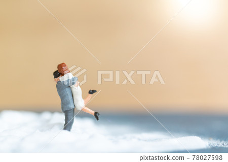 Miniature people Happy wedding couple on white beach Miniature people Happy wedding couple on white beach 78027598