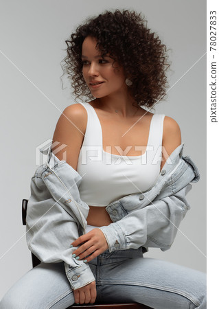 Stylish curly haired woman in denim outfit Stylish curly haired woman in denim outfit 78027833