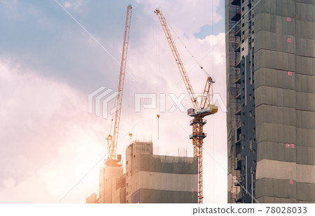 Construction site with crane and building. Real estate industry. Crane use reel lift up equipment in construction site. Apartment building construction site. Construction crane work against the sky. 78028033