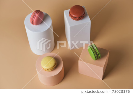 Tasty macarons on trendy geometric pedestals on a beige background 78028376