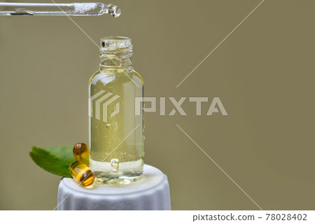 drop of citrus oil close-up macro drips from a pipette into a bottle 78028402