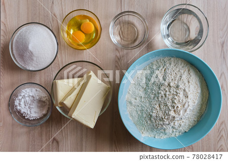 Basic food cooking ingredients around on wooden table. Basic food cooking ingredients around on wooden table. 78028417