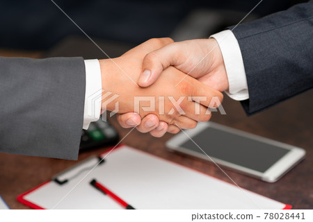 Corporate Businessmen Handshake Indoors.Two People Professionally Well Dressed Gesturing Togetherness.Working Colleague Partners Sign Deal In Agreement To Contract 78028441