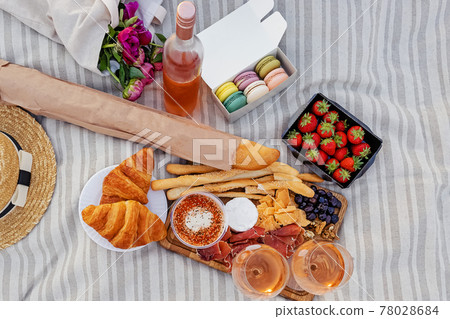 Picnic with strawberries, croissants and appetizers on the board and rose wine Picnic with strawberries, croissants and appetizers on the board and rose wine 78028684