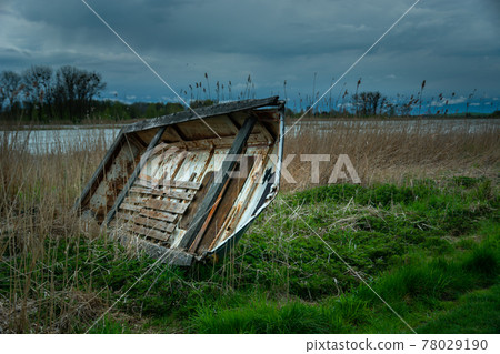 Old wrecked boat on the shore of the lake and storm clouds, Stankow, Poland Old wrecked boat on the shore of the lake and storm clouds, Stankow, Poland 78029190